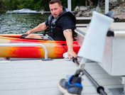 guy grabbing paddle off of dock