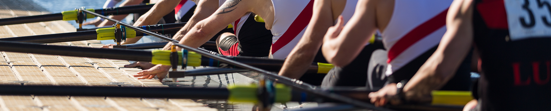 Rowing team in boat beside dock