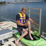 guy getting into kayak on launch area