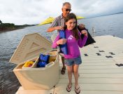 Man putting life jacket on little girl