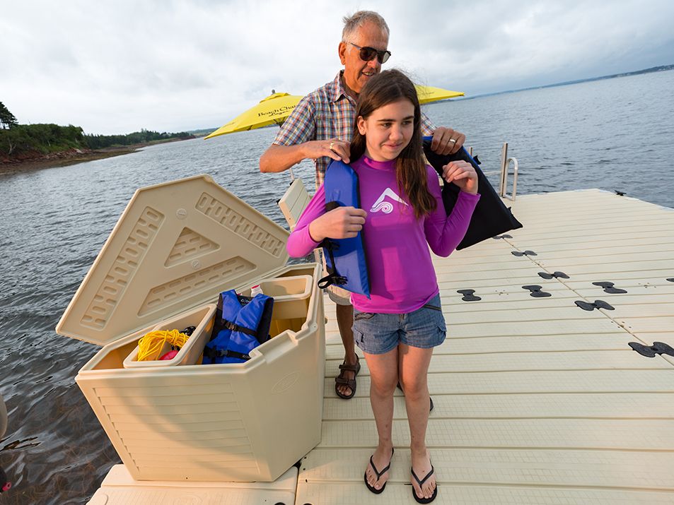 Man putting life jacket on little girl