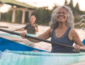 A woman smiles while kayaking