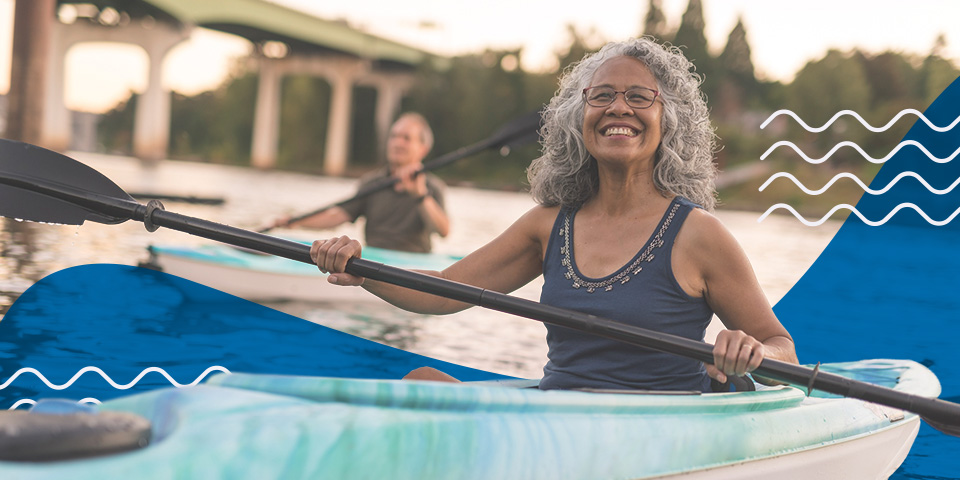 A woman smiles while kayaking