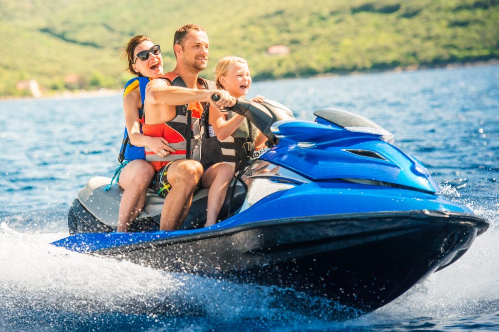 Parents and child on blue jet ski