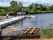 Family on floating dock with wooden frame in grass