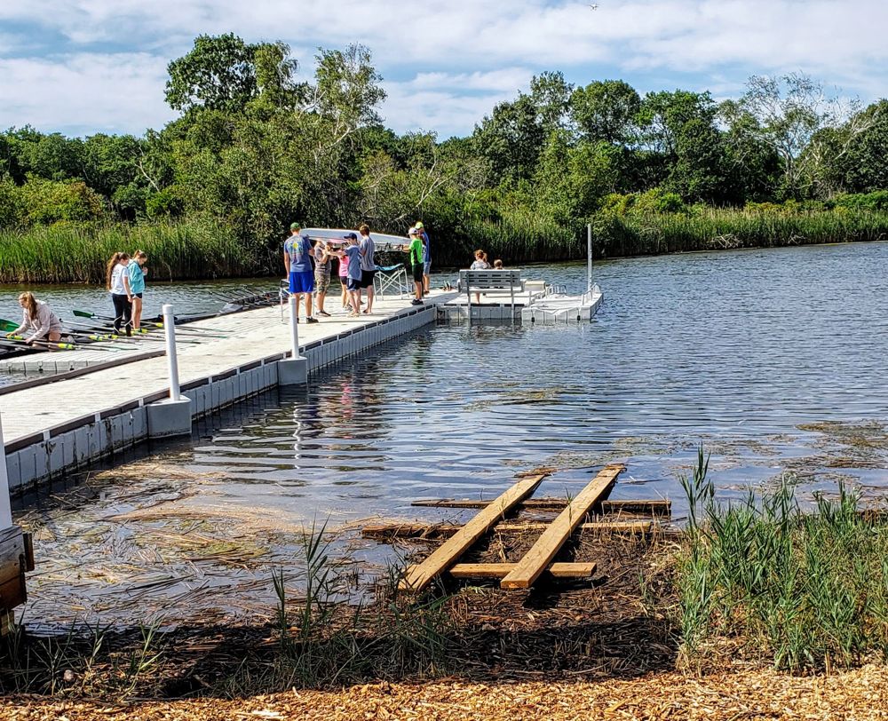 Family on floating dock with wooden frame in grass