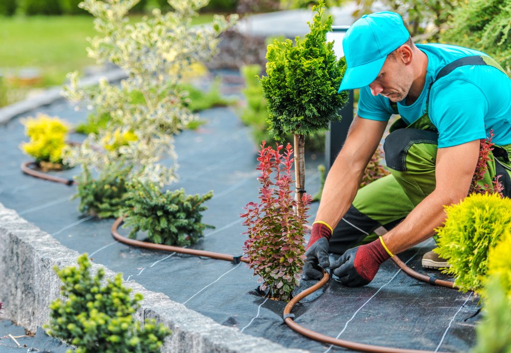 Man adjusting irrigation system in garden