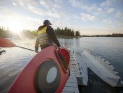 Guy carrying kayak to launch area