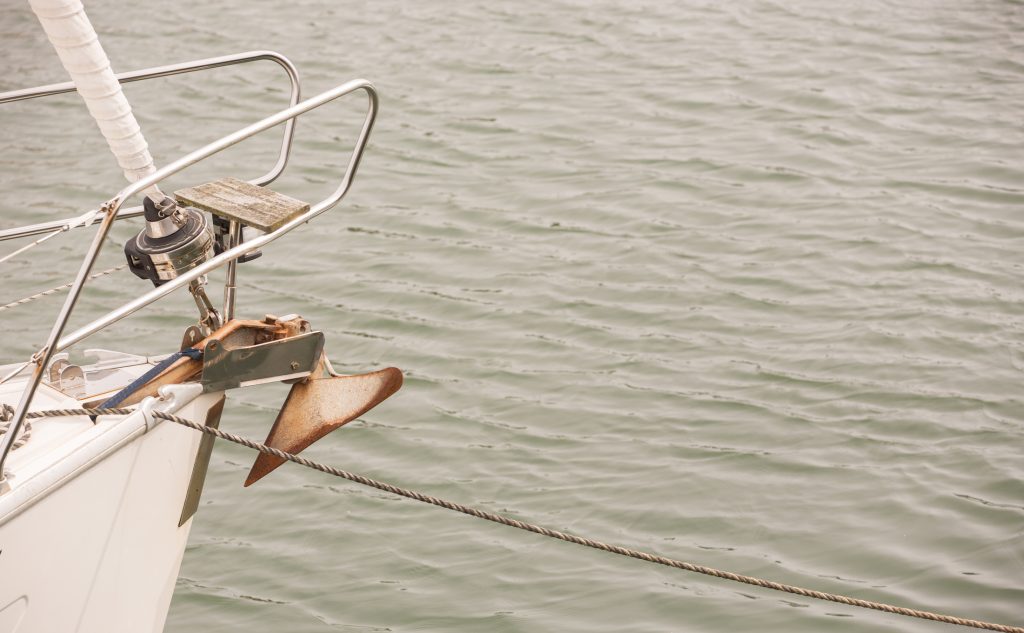 Sailing boat with anchor hanging from the front of the boat