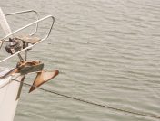 Sailing boat with anchor hanging from the front of the boat