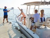 Woman tossing rope to man to anchor boat