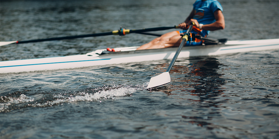 Man rowing with paddles moving in water